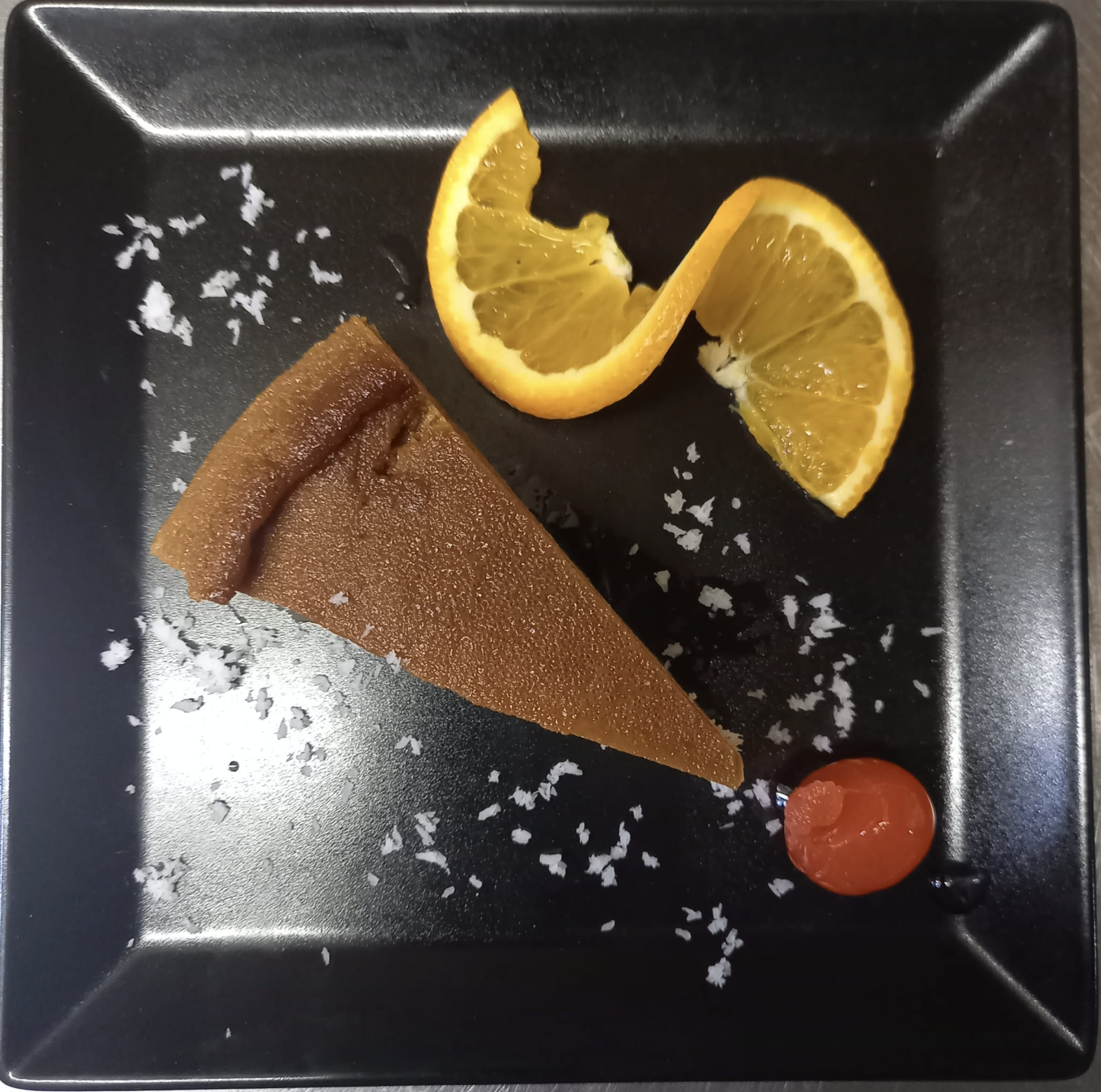 Cuban flan plated with orange slices