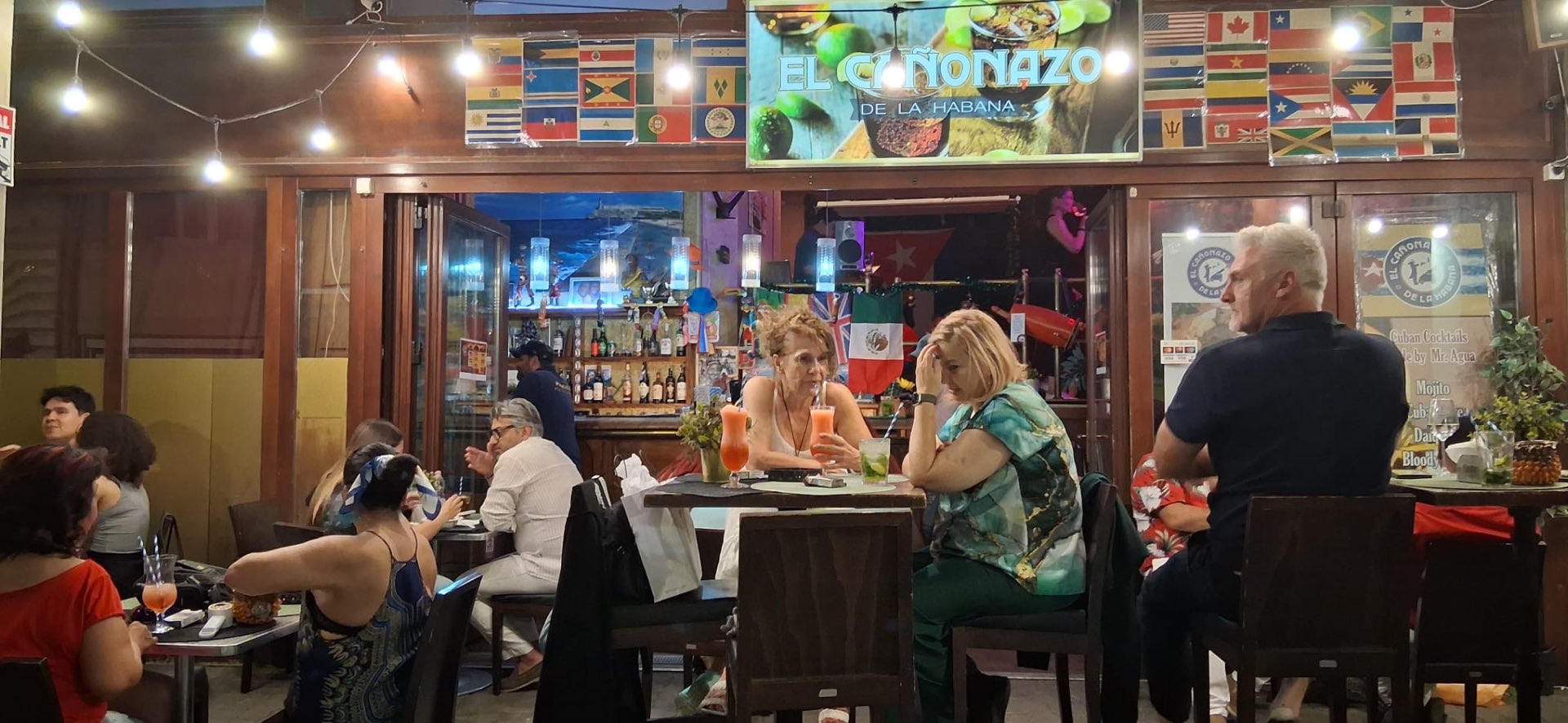 Ambiente del bar con clientes disfrutando cócteles